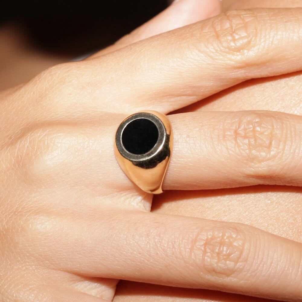 Model wearing Black Hole Ring in yellow gold with onyx center stone