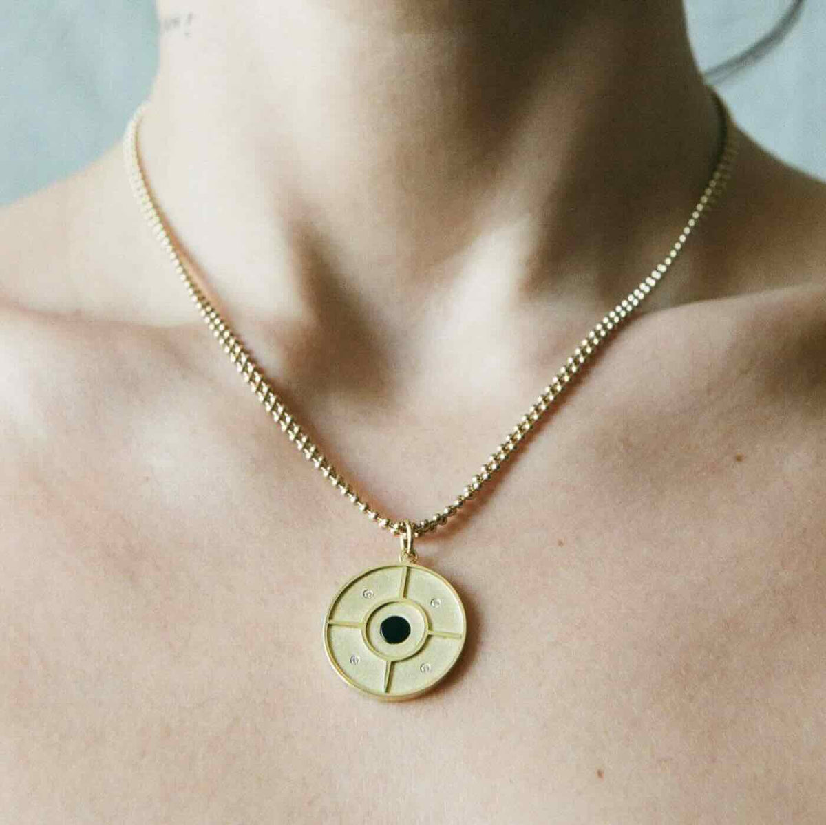 Model wearing Choice Pendant in yellow gold with onyx center stone and white diamonds