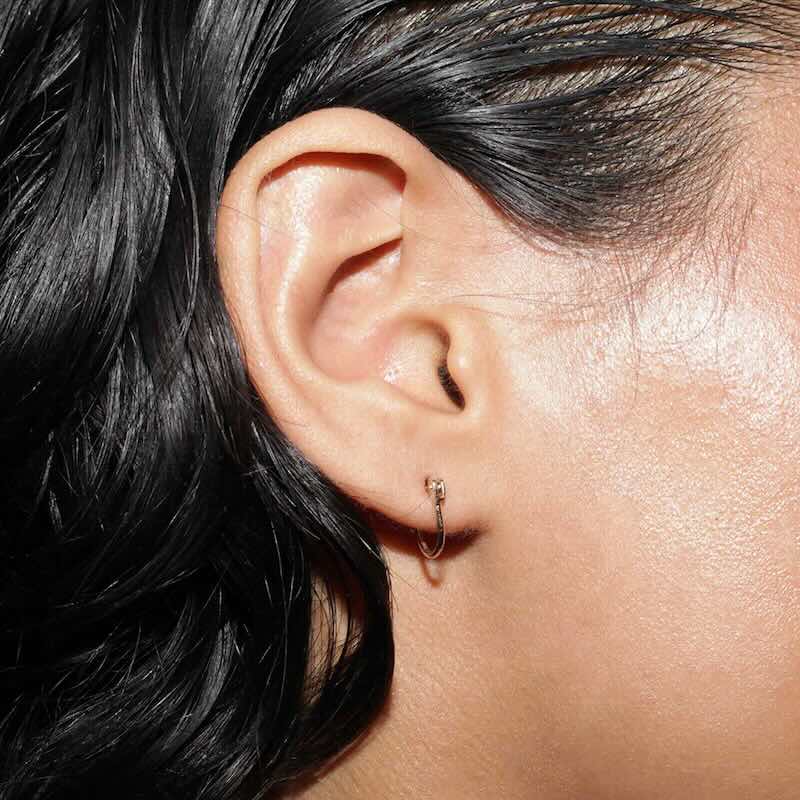 Model wearing Huggie Latch Earring in yellow gold
