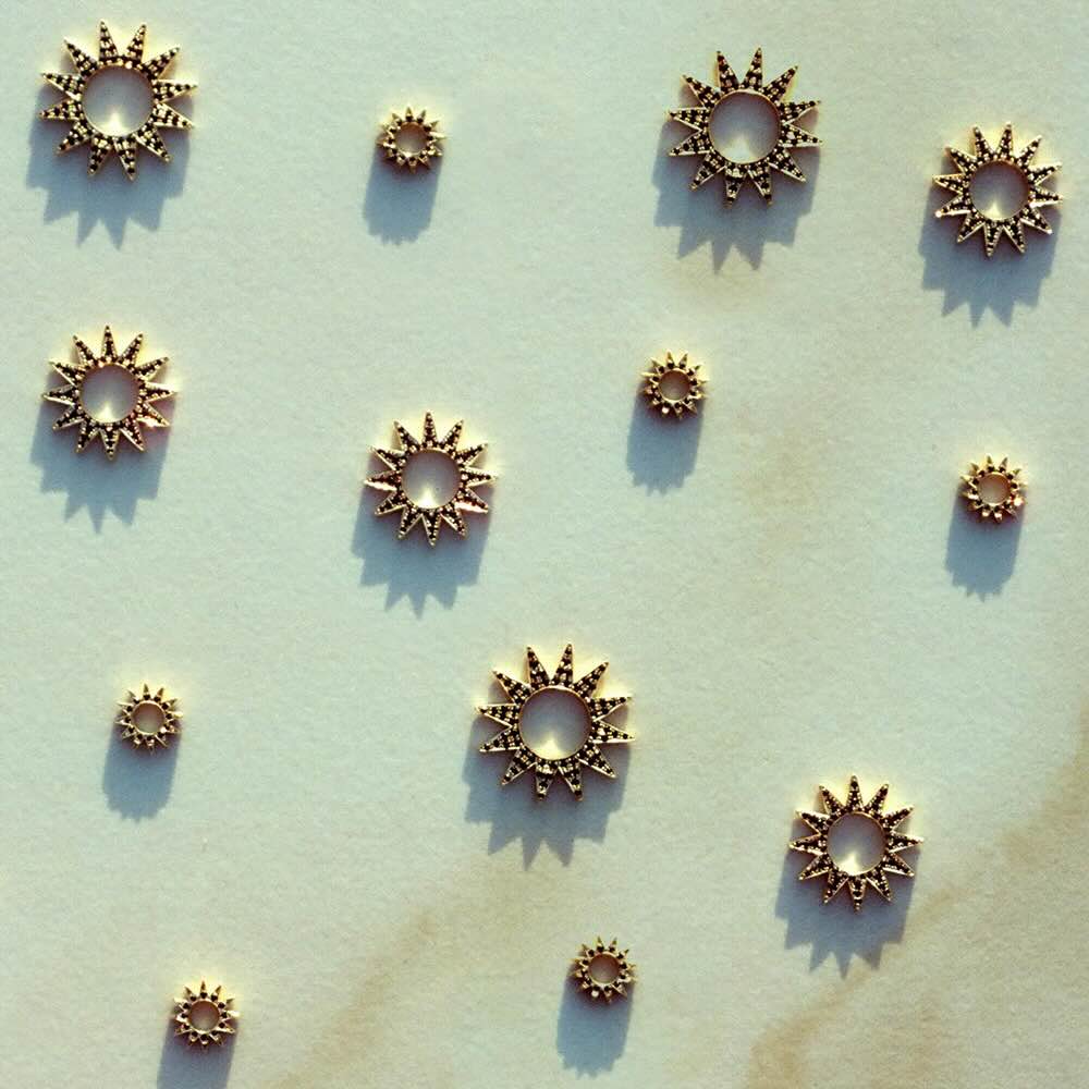 Pavé Baby Spur Earring Charms in yellow gold with black pavé diamonds on flat surface