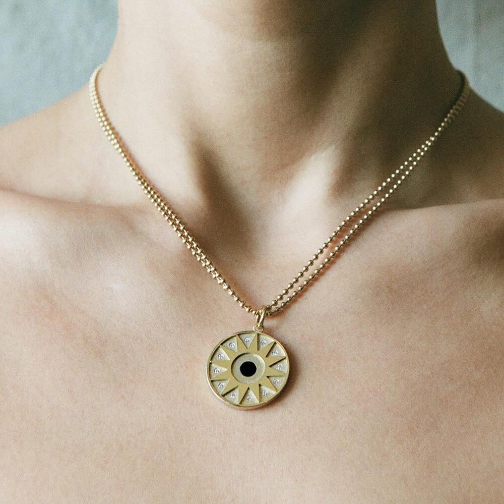 Model wearing Star Pendant in yellow gold with onyx center stone and white diamonds